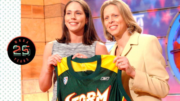 Sue Bird holding up a Seattle Storm jersey
